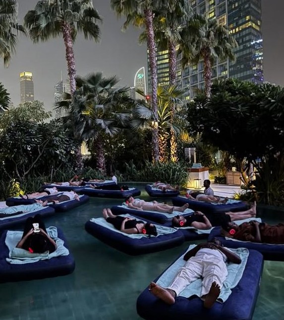 Guests floating on water during an evening breathwork session